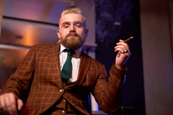 rich caucasian business man in suit smoke a cigar
