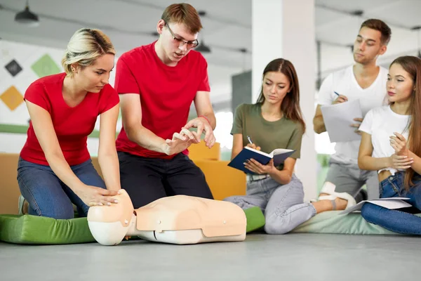 Třída CPR s kavkazskými instruktory, kteří mluví a demonstrují pomoc — Stock fotografie