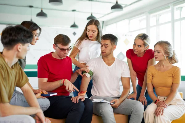 El instructor masculino utiliza torniquete para prevenir el sangrado durante el entrenamiento de primeros auxilios — Foto de Stock