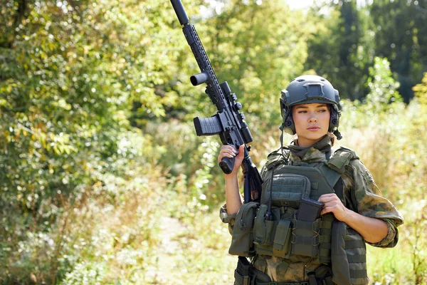 Portrait de femme militaire confiante avec une arme dans la forêt — Photo