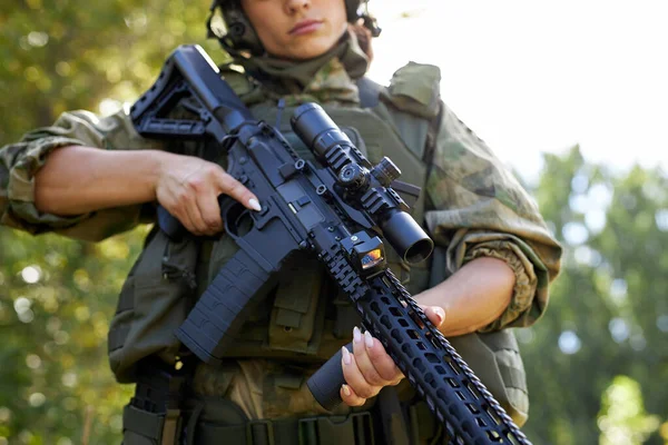 Junge kaukasische Militärfrau hält in der Natur ein Gewehr in der Hand — Stockfoto