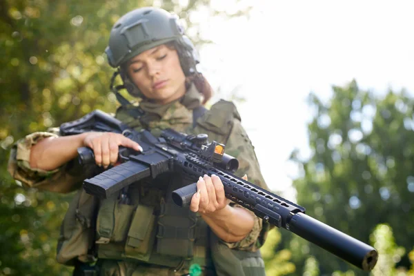 Militär kvinna kollar geväret i skogen — Stockfoto