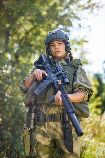 Soldado valente exército feminino forte com arma de espingarda em pé na floresta — Fotografia de Stock