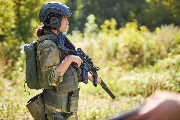 Stark modig kvinnlig armé soldat med gevär kulspruta står i skogen — Stockfoto