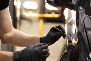 Erkek elleri boya yapmak ya da toprağı temizlemek için detaylı fırça kullanır.