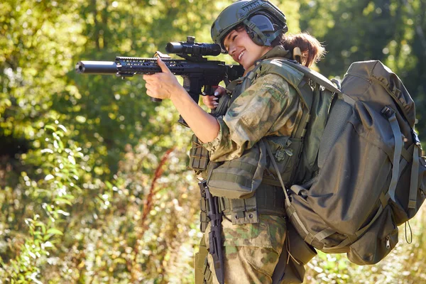 Sportig kvinna soldat skytte med gevär kulspruta i skogen — Stockfoto
