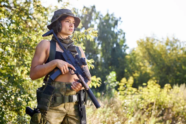 Ung jägare kvinna i toppen med en pistol under jakten på vilda fåglar — Stockfoto