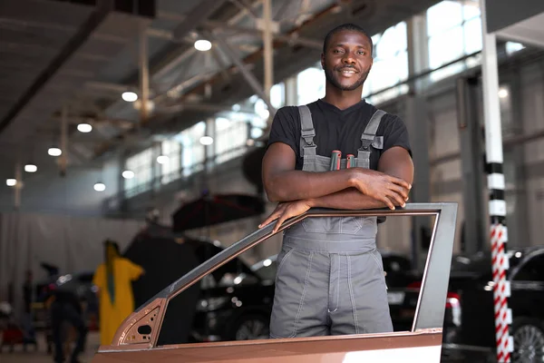 Portret van positieve afro-Amerikaanse auto monteur in uniform — Stockfoto