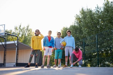 Çeşitli şehirli gençler birlikte basketbol oynamaya hazır.