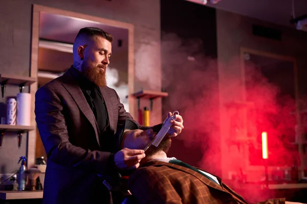 Caucasico hipster cliente uomo in visita nel negozio di barba barba barba da parrucchiere professionista — Foto Stock