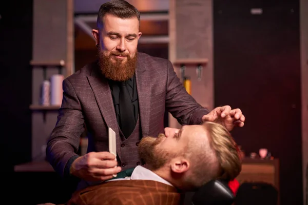 白人ヒップスタークライアント男訪問で理容師店シェービングひげによってプロの美容師 — ストック写真