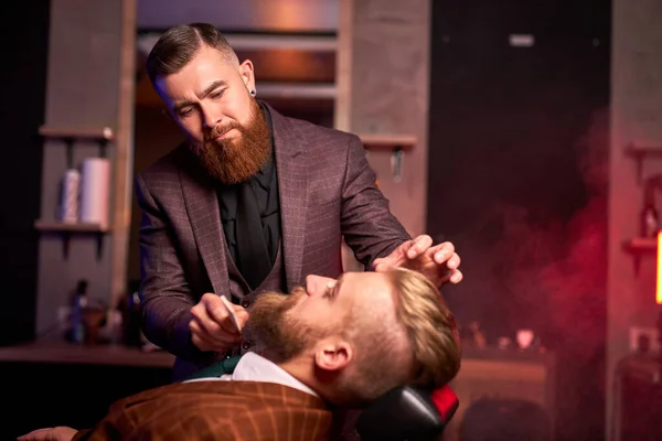 Caucasico hipster cliente uomo in visita nel negozio di barba barba barba da parrucchiere professionista — Foto Stock