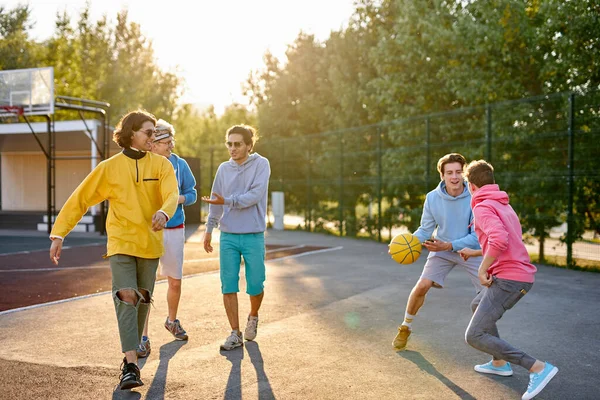 Groep van jonge mannelijke tieners spelen basketbal buiten — Stockfoto