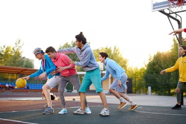 Yakala onu. Mutlu gençler basketbol oynuyorlar, kazanmak istiyorlar.