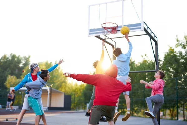Släng dunken. unga basketspelare kastar boll i basket båge på lekplatsen — Stockfoto