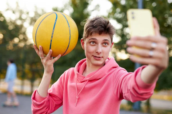 Guapo caucásico adolescente chico tomar selfie en smartphone celebración de baloncesto pelota —  Fotos de Stock