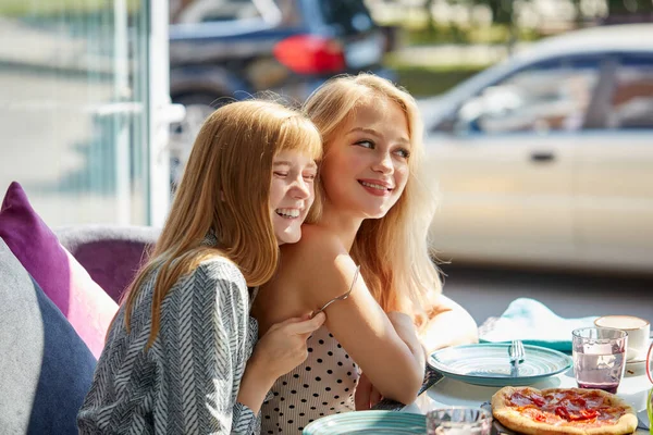 Vriendinnen lachen, veel plezier tijdens het zitten in restaurant — Stockfoto