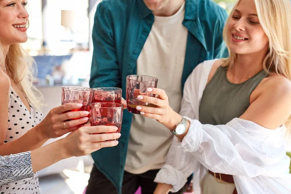 Grupo de jóvenes caucásicos celebrando cumpleaños con tintineo vaso de bebida — Foto de Stock