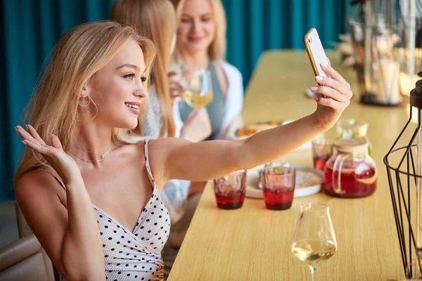 Linda rubia hembra tomar selfie en café — Foto de Stock