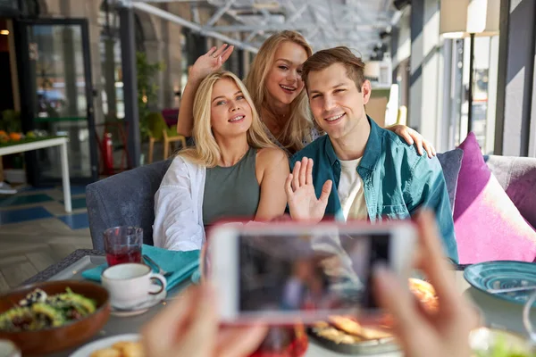 Drie vrienden poseren voor foto op smartphone — Stockfoto