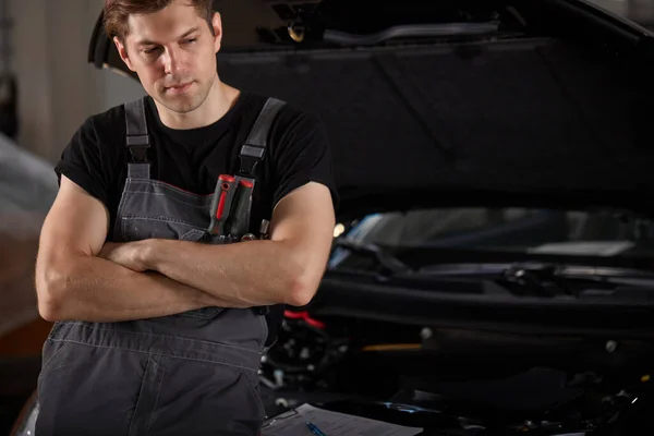 Portrét smutného automechanika stojícího vedle auta — Stock fotografie