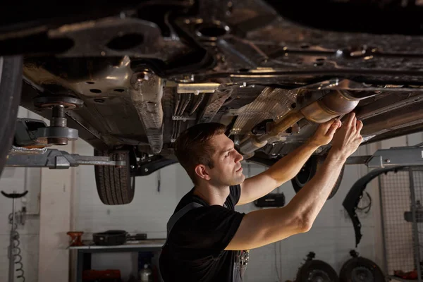 Stilig kaukasisk hane reparera botten av bilen — Stockfoto