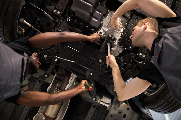 Twee gemengde ras auto monteur mannen hebben succesvol werk — Stockfoto