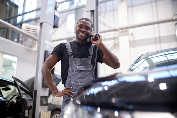 Portret van een positieve Afrikaanse man met power buffer machine voor het polijsten van een auto — Stockfoto