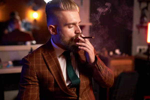 Portrét pohledného dospělého muže ve formálním kostýmu kouření doutníku — Stock fotografie