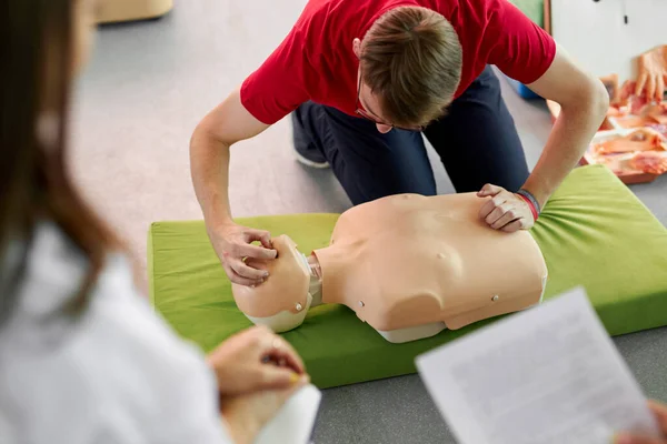 CPR class with caucasian instructors speaking and demonstrating help first aid