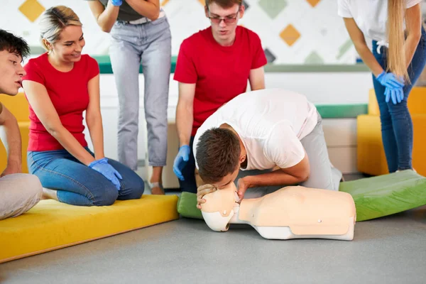 CPR class with caucasian instructors speaking and demonstrating help first aid