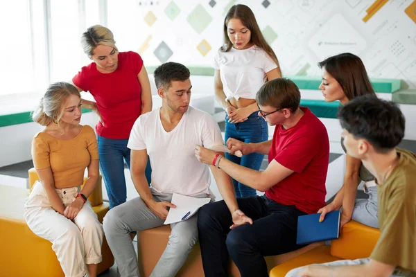 İlk yardım eğitim sınıfında, bir grup öğrenci hastanın elini sabitlemeyi öğreniyor. — Stok fotoğraf