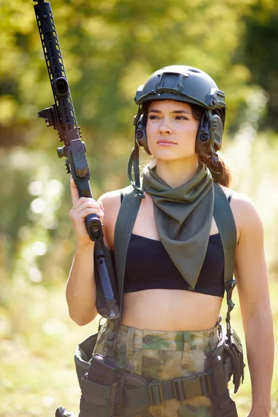 Retrato de una mujer militar confiada con un arma en el bosque — Foto de Stock