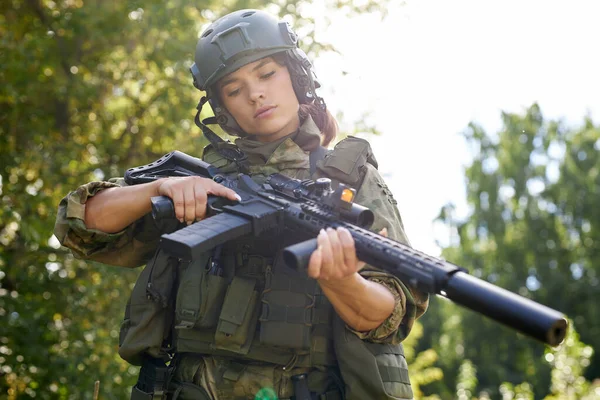military woman is checking details of weapon