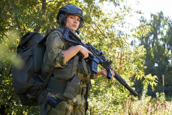 Junge kaukasische Militärfrau hält in der Natur ein Gewehr in der Hand — Stockfoto