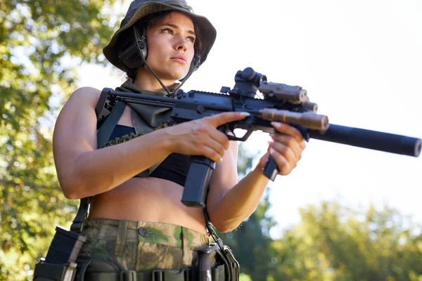 Jovem caçador mulher no topo com uma arma durante a caça em busca de pássaros selvagens — Fotografia de Stock