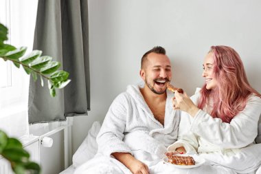 Çok tatlı bir kadın kocasına ay çöreği ikram ediyor.