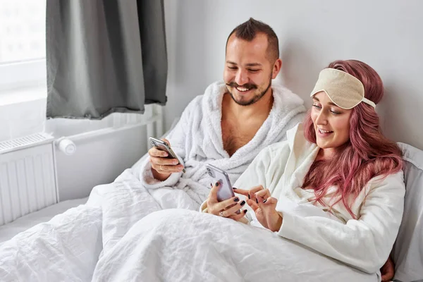 Couple marié se reposer avec smartphone sur le lit — Photo