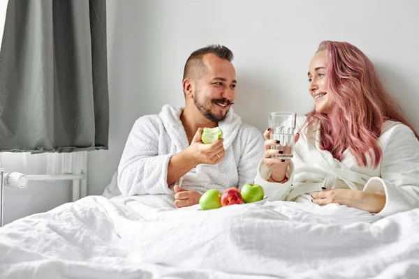 행복 한 부부가 침대에서 아침 식사를 즐긴다 — 스톡 사진