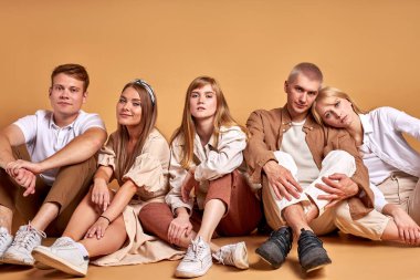 Dost canlısı bir grup öğrenci stüdyoda yerde yatıyor.