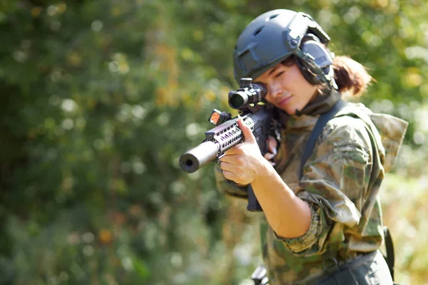 Mujer deportiva soldado disparando con ametralladora en el bosque —  Fotos de Stock
