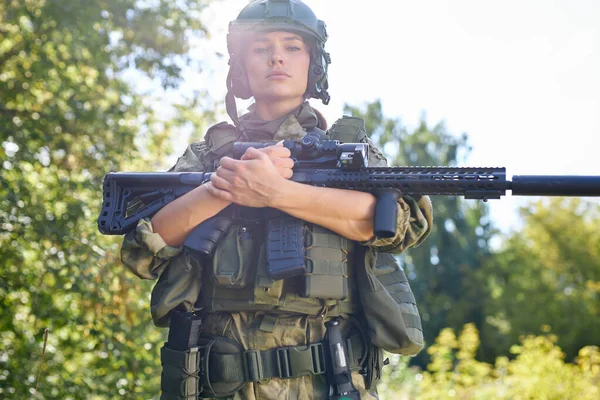 Stark modig kvinnlig armé soldat med gevär kulspruta står i skogen — Stockfoto