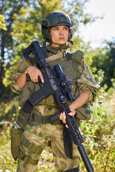 Stark modig kvinnlig armé soldat med gevär kulspruta står i skogen — Stockfoto