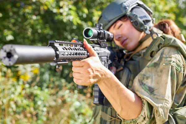 Sportig kvinna soldat skytte med gevär kulspruta i skogen — Stockfoto