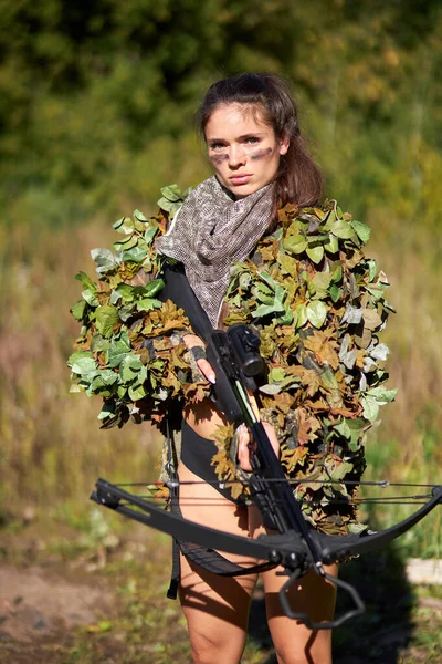 Jovem caucasiano mulher inteligente caçador de veados em uniforme verde com disfarce e rifle na floresta — Fotografia de Stock