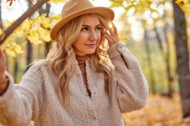 Çekici bir bayan sonbahar ormanlarında eğleniyor, doğa.