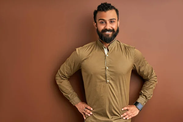 Indian man with a happy and cool smile on face isolated on brown studio background — Stock Photo, Image