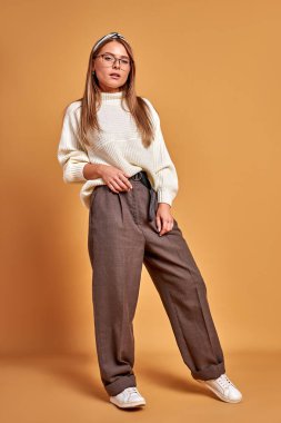 Gözlüklü kadın kameraya özgüvenle bakıyor.