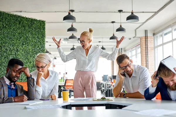 Boze onevenwichtige vrouwelijke baas schreeuwt, berispt werknemers voor het niet uitvoeren van het plan op het werk — Stockfoto