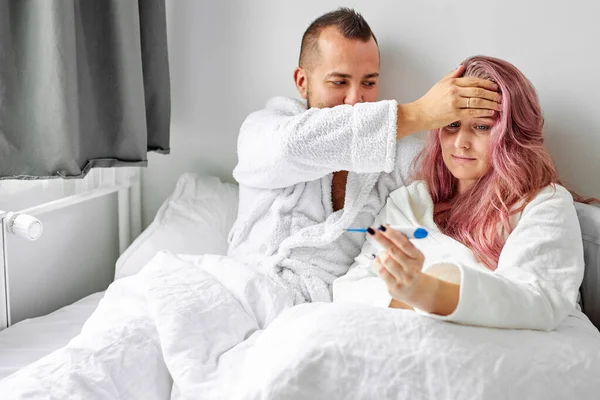 Mujer enferma con marido en la cama — Foto de Stock